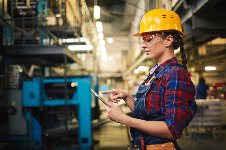 female engineer using tablet to manage manufacturing equipment